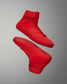 A pair of high-top red athletic shoes is prominently displayed against a gray background, featuring a textured upper and grip-patterned soles, combining style and functionality.