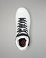 White wrestling shoe with black laces and red logo on a gray background