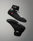 Black wrestling shoes with white laces on a gray background