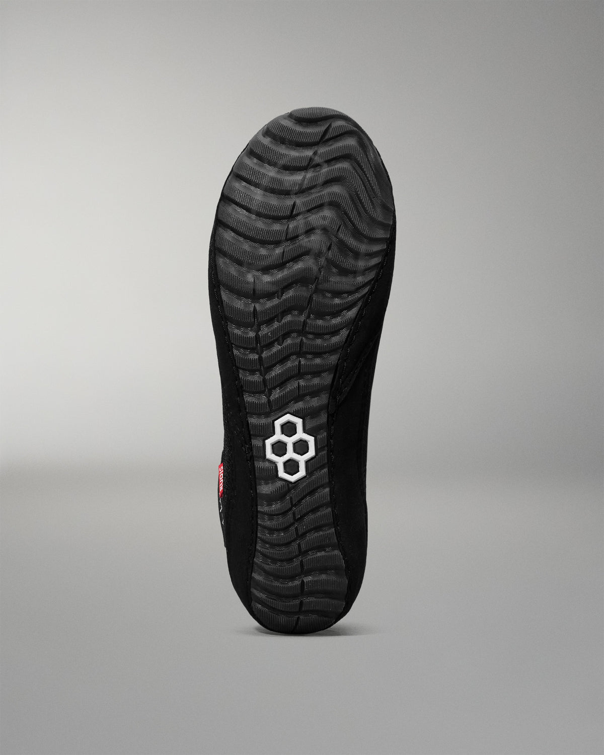 Black wrestling shoe sole with a brand logo on a gray background