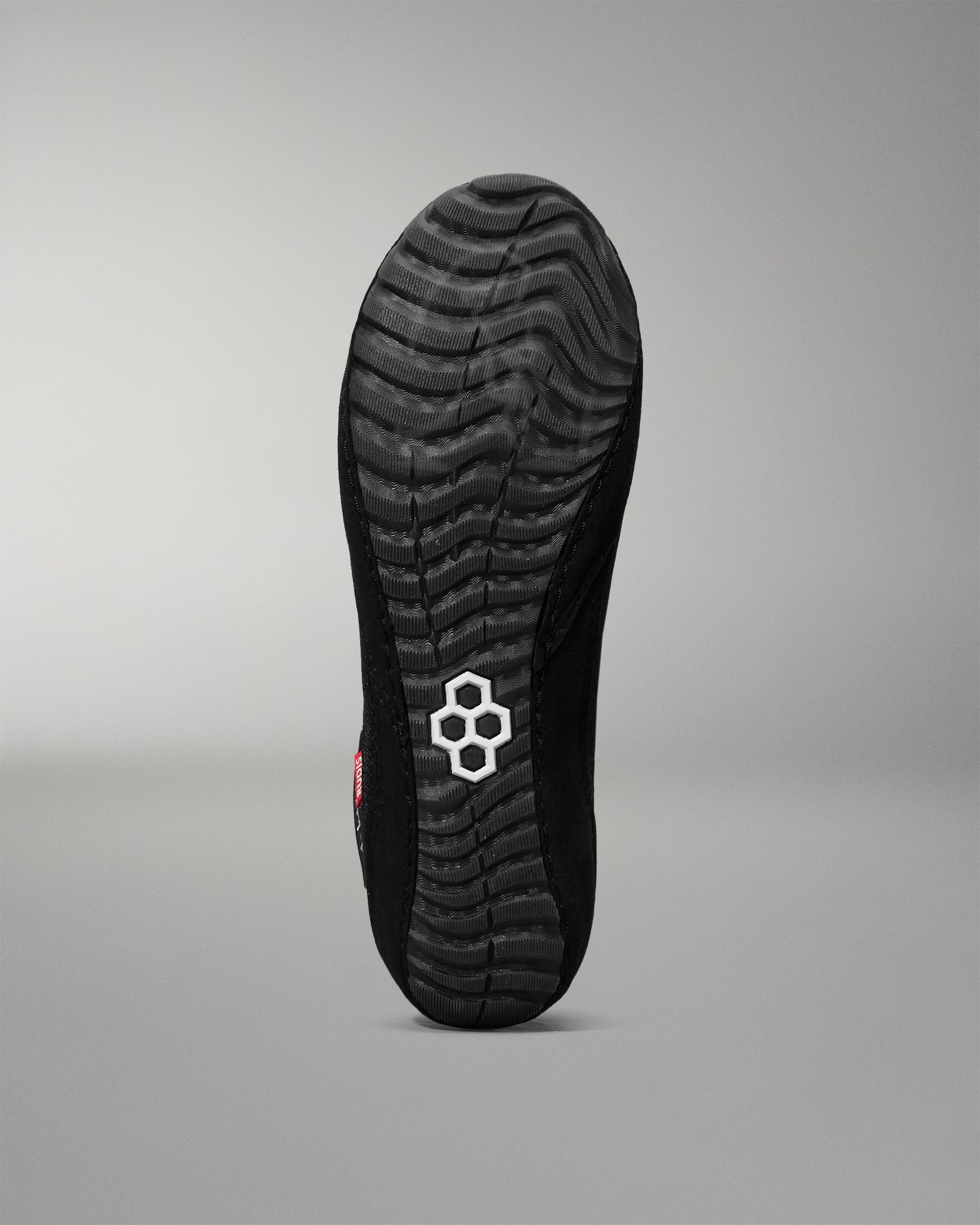 Black wrestling shoe sole with a brand logo on a gray background