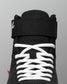Black wrestling shoe with white laces on a gray background