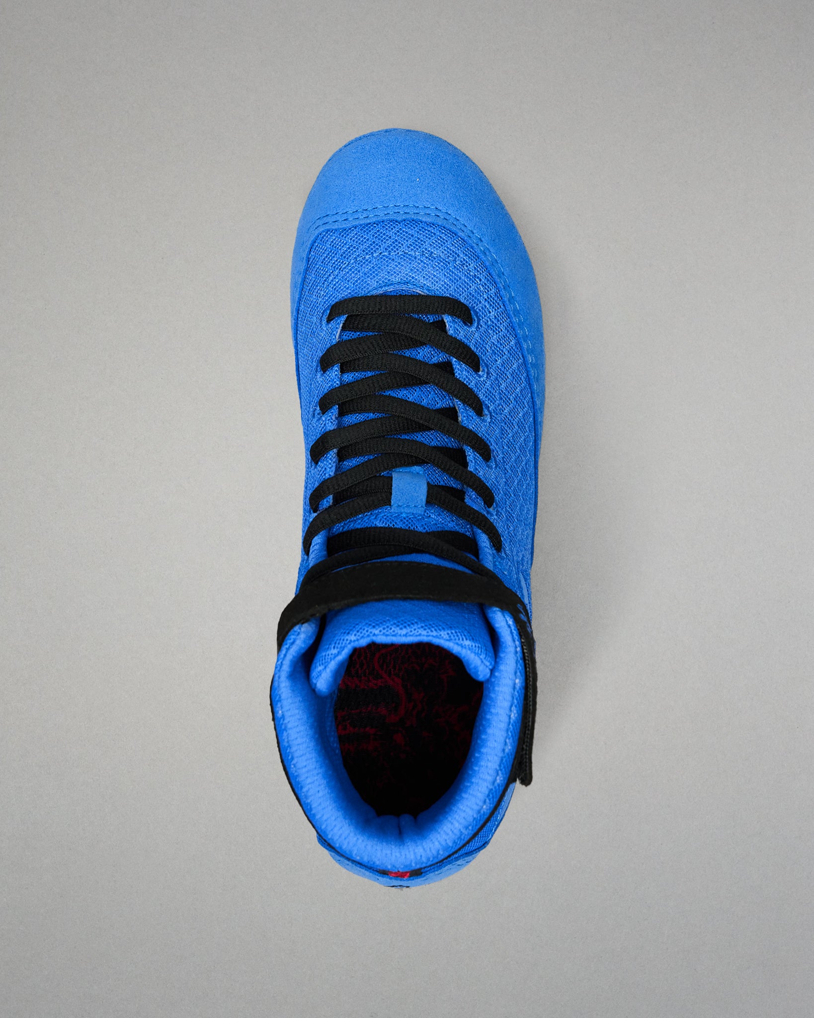 Top view of RUDIS Samurai Speed Ikigai wrestling shoe highlighting black laces, blue mesh tongue, padded collar, and ankle strap.