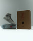 RUDIS Samurai Speed Kokoro wrestling shoes displayed beside branded packaging, showcasing gray mesh uppers, black laces, translucent soles, and signature RUDIS graphics.