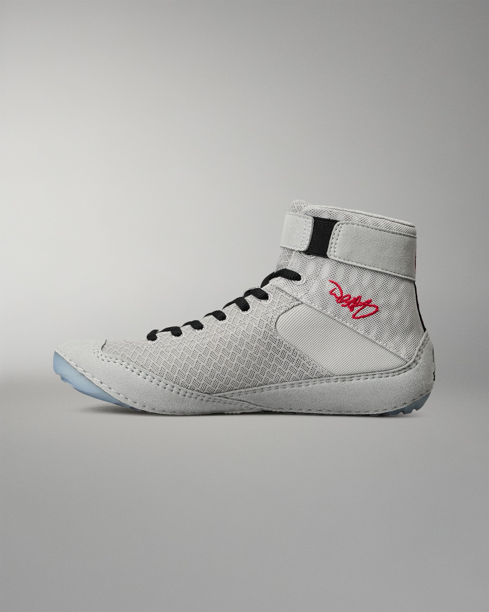 Medial side view of the RUDIS Samurai Speed Kokoro wrestling shoe, showcasing black laces, textured gray panels, ankle strap, and red embroidered signature detail.