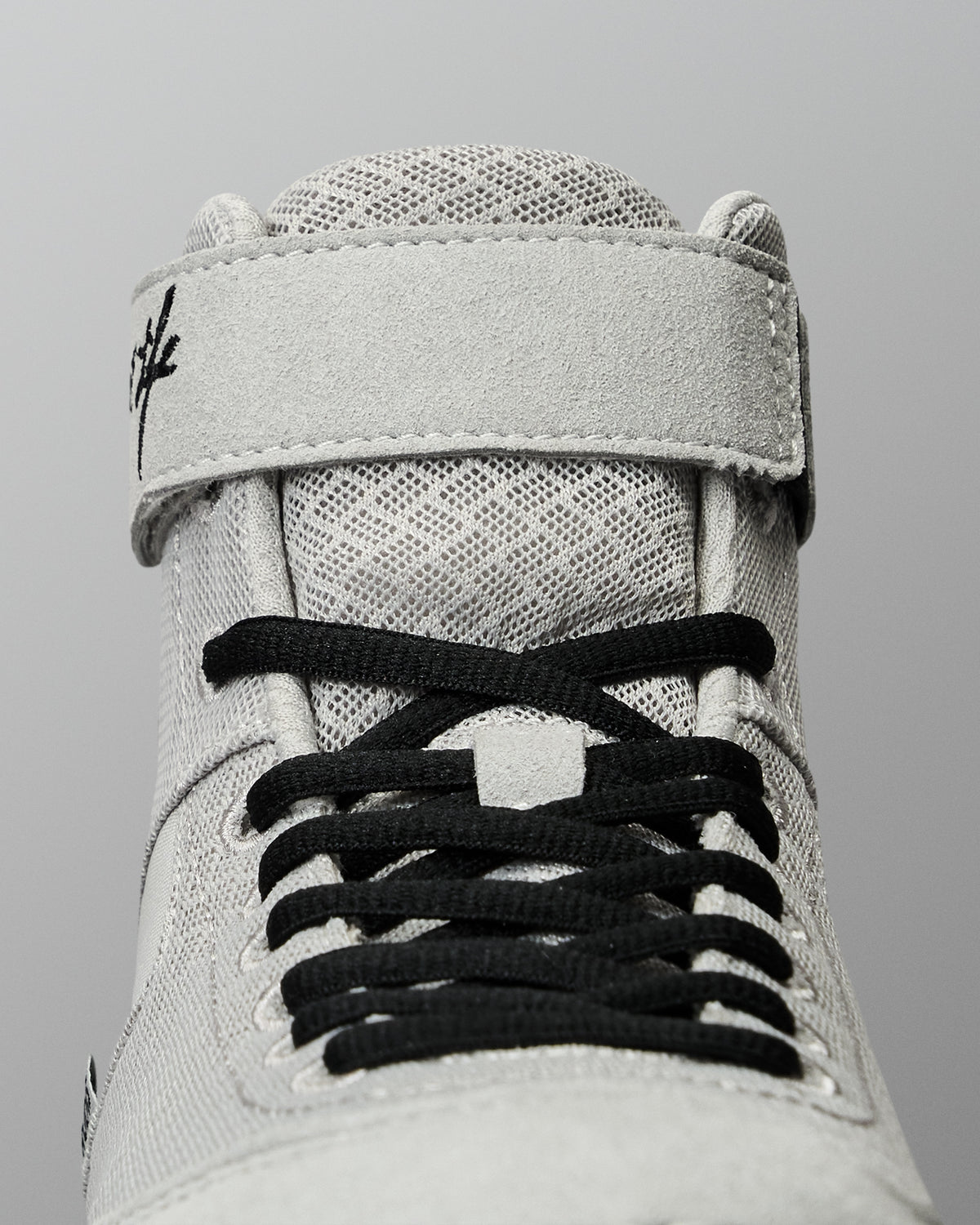 Close-up of the RUDIS Samurai Speed Kokoro wrestling shoe, highlighting black laces, breathable-looking mesh texture, padded tongue, and gray ankle strap construction.