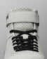 Close-up of the RUDIS Samurai Speed Kokoro wrestling shoe, highlighting black laces, breathable-looking mesh texture, padded tongue, and gray ankle strap construction.