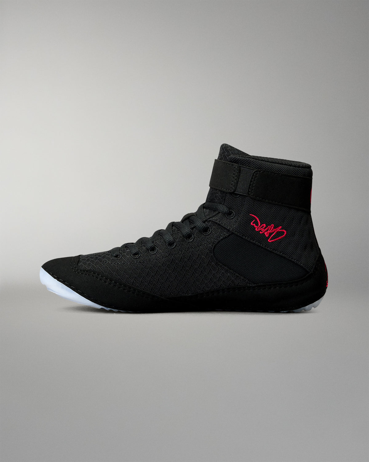 Inner side view of the RUDIS Samurai Speed Wabi-Sabi wrestling shoe in black, showing textured mesh, red embroidered signature, ankle strap, and translucent outsole.