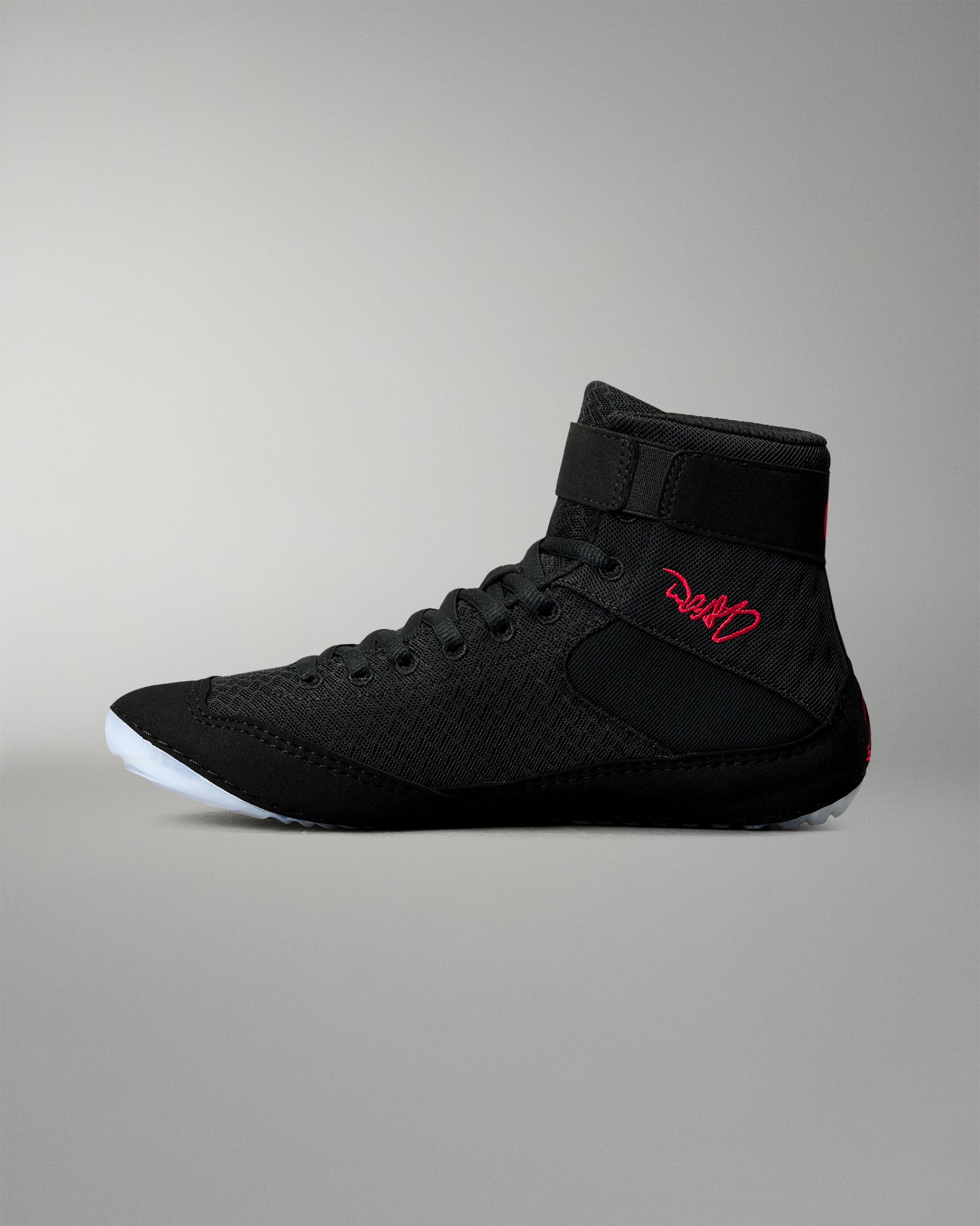 Inner side view of the RUDIS Samurai Speed Wabi-Sabi wrestling shoe in black, showing textured mesh, red embroidered signature, ankle strap, and translucent outsole.