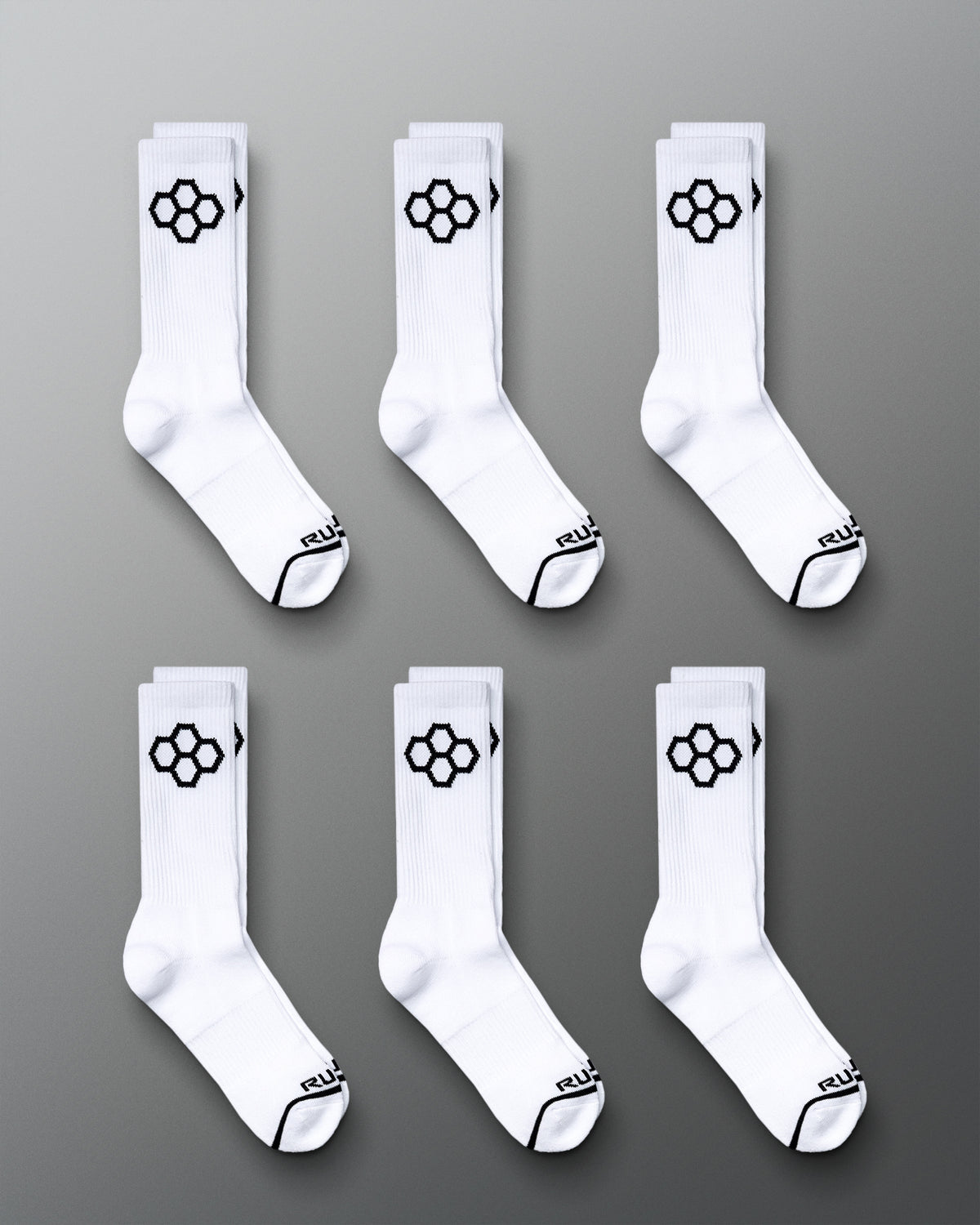 This image displays six pairs of white sports socks featuring a distinctive black hexagonal logo on the sides and black accents on the toes