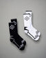 A pair of athletic socks in black and white featuring modern designs with hexagonal patterns and contrasting accents