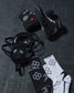 Black wrestling shoes, headgear, and socks with a logo on a dark textured surface