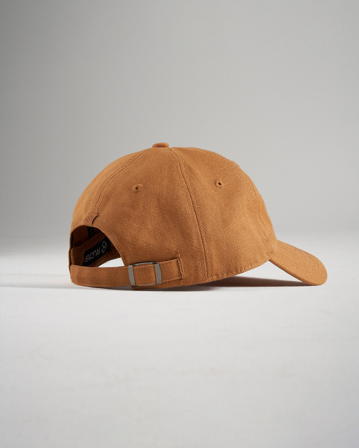 A stylish brown baseball cap with a relaxed fit featuring a soft fabric and an adjustable strap for comfort
