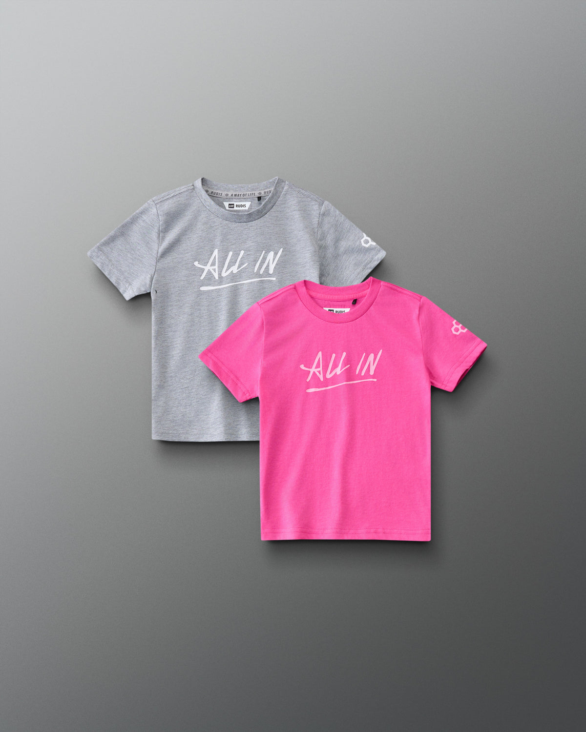 Front view of RUDIS Motto Scripted Toddler Elite Super Soft T-Shirt 2-Pack in pink and gray, featuring ALL IN chest graphics and RUDIS sleeve logos.