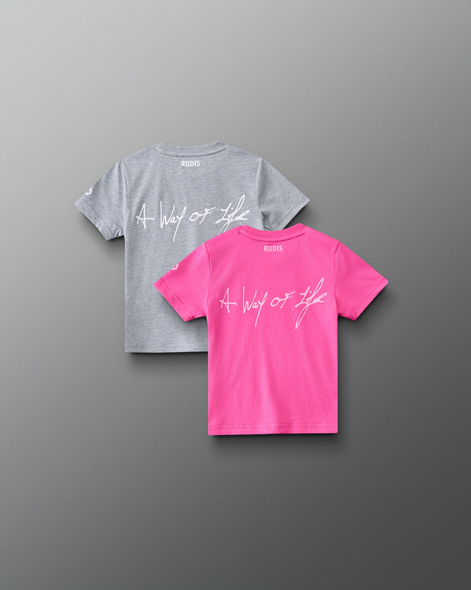 Back view of RUDIS Motto Scripted toddler t-shirts in pink and gray, featuring A Way of Life script graphics and RUDIS branding below the neckline.