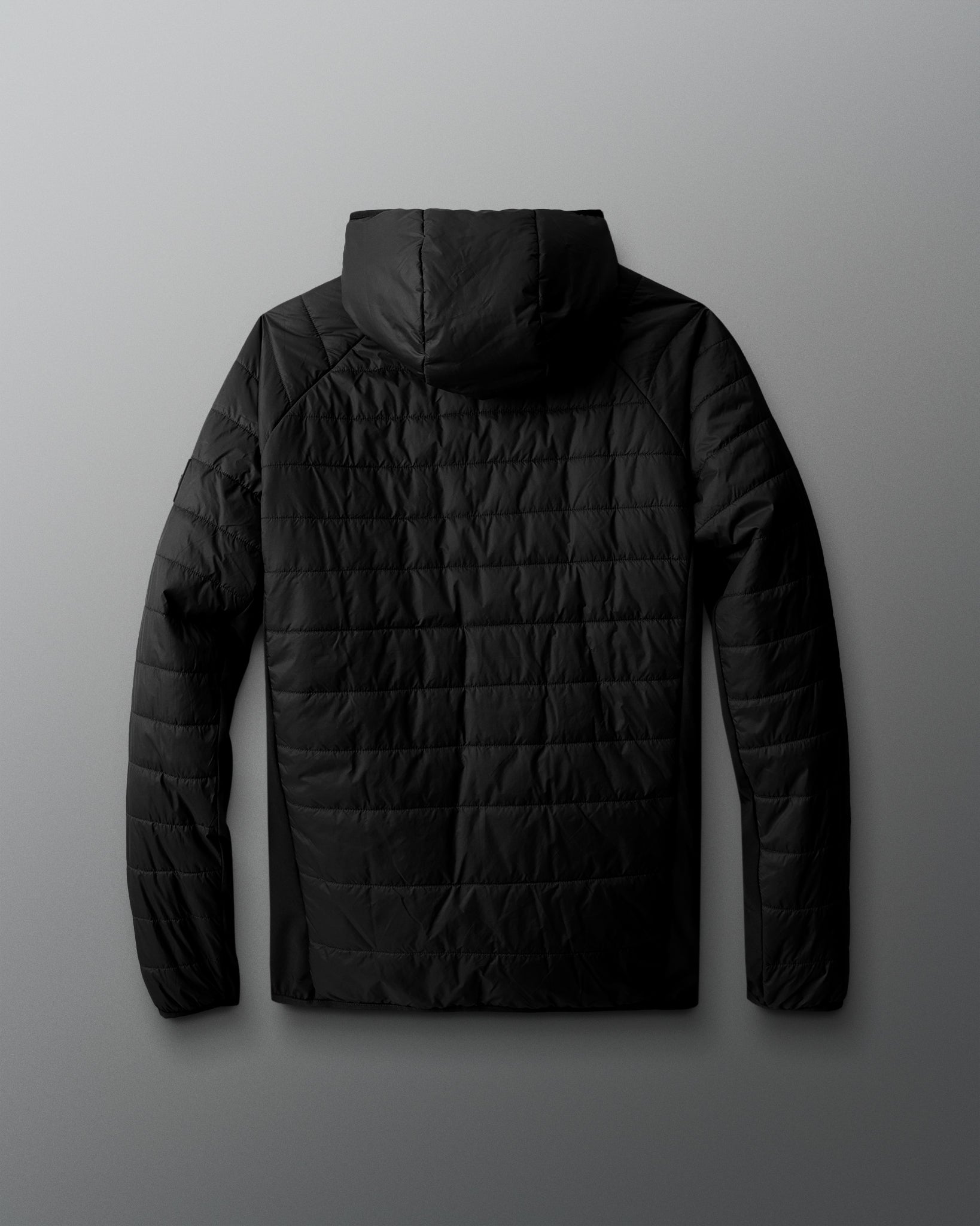 Black quilted jacket on a gray background