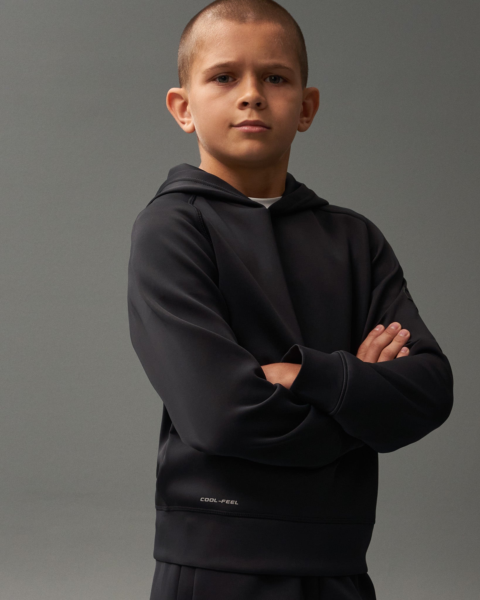 Child wearing a black hoodie with 'Cool-Flow' text on a gray background