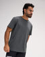 Model wearing the RUDIS Performance Heather T-Shirt in Heather Carbon, featuring medium-gray heathered fabric, short sleeves, a crew neckline, and subtle RUDIS shoulder branding.