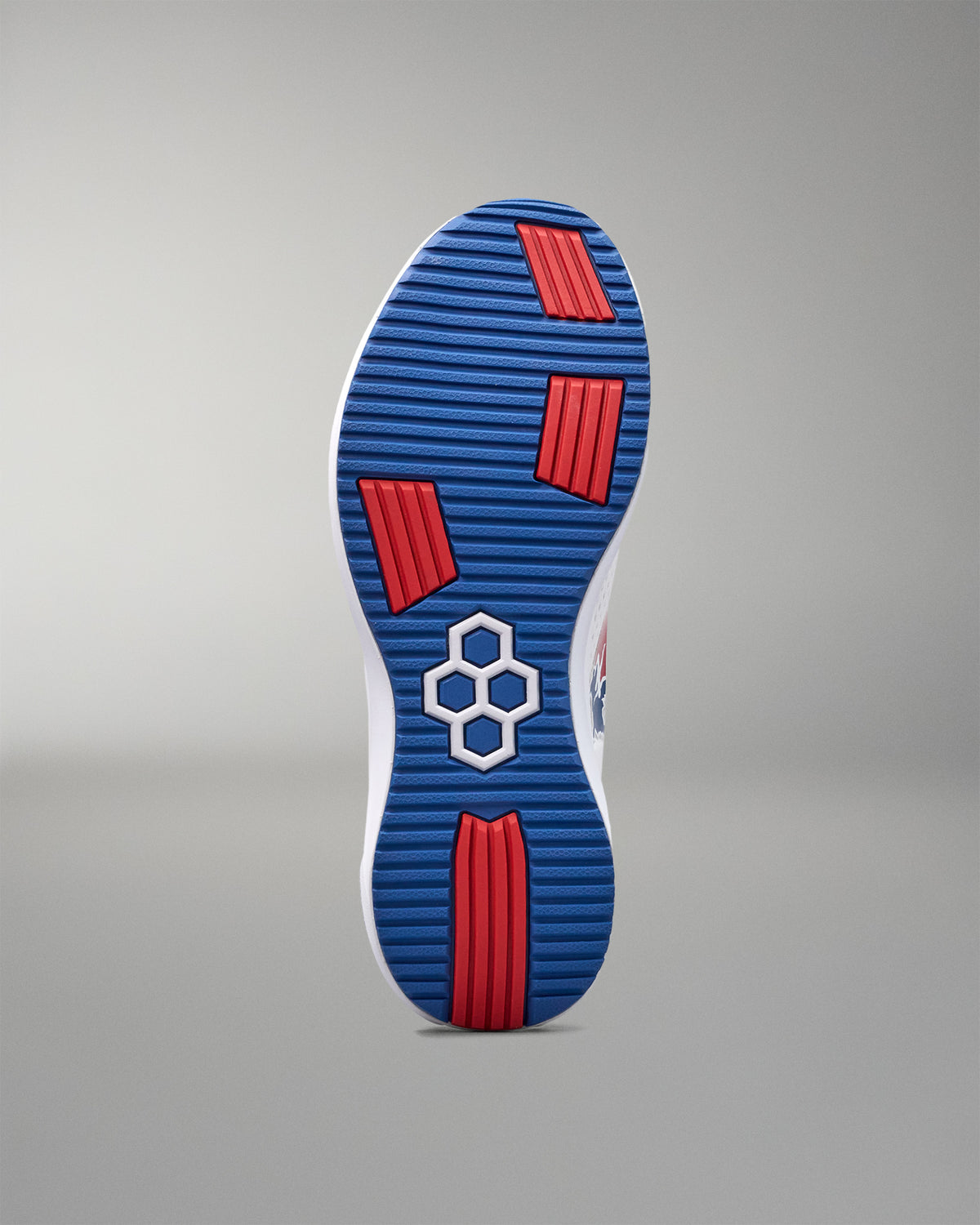 Sole of a shoe with blue pattern and red accents on a gray background