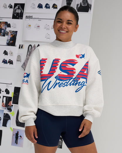 Female model wearing the RUDIS USA Wrestling Comfort Fleece Mockneck sweatshirt in Heather Silver with oversized red and blue USA Wrestling graphics