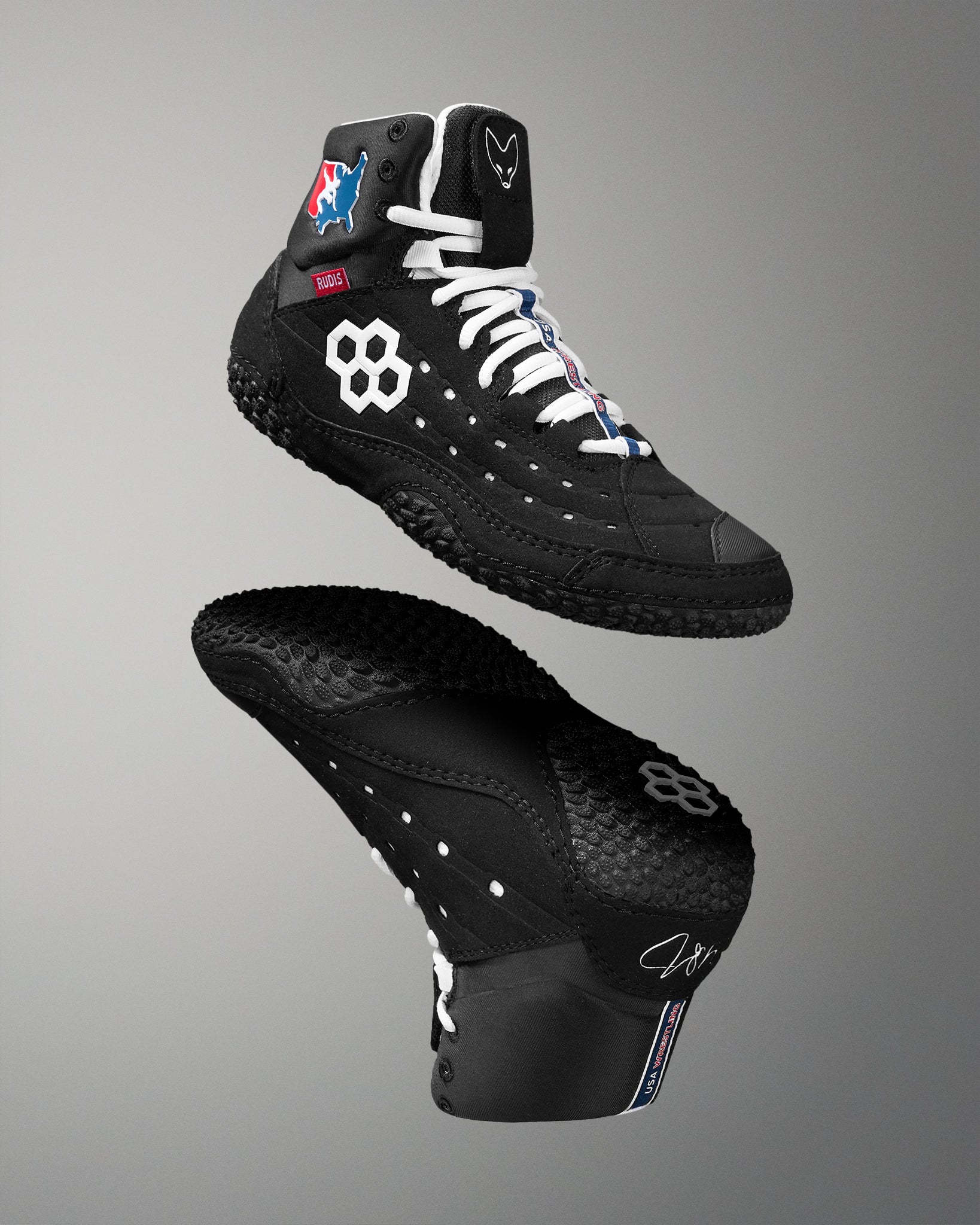 Black Wrestling shoes with white laces on a gray background
