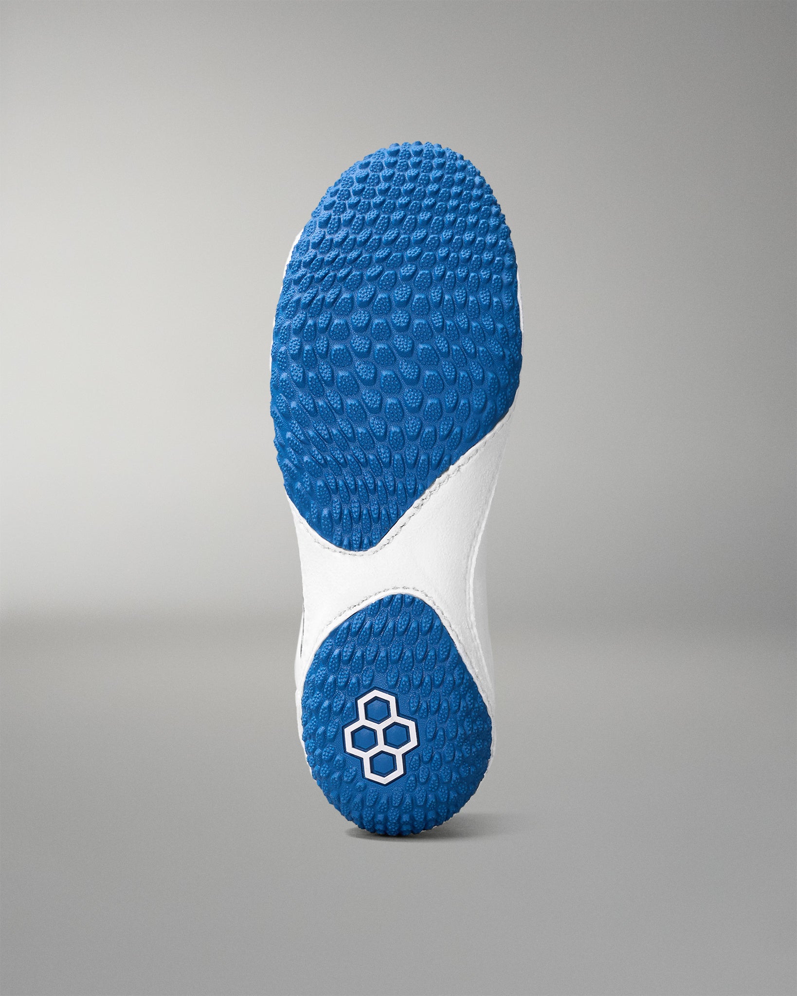 Close-up of a blue and white wrestling shoe sole on a gray background
