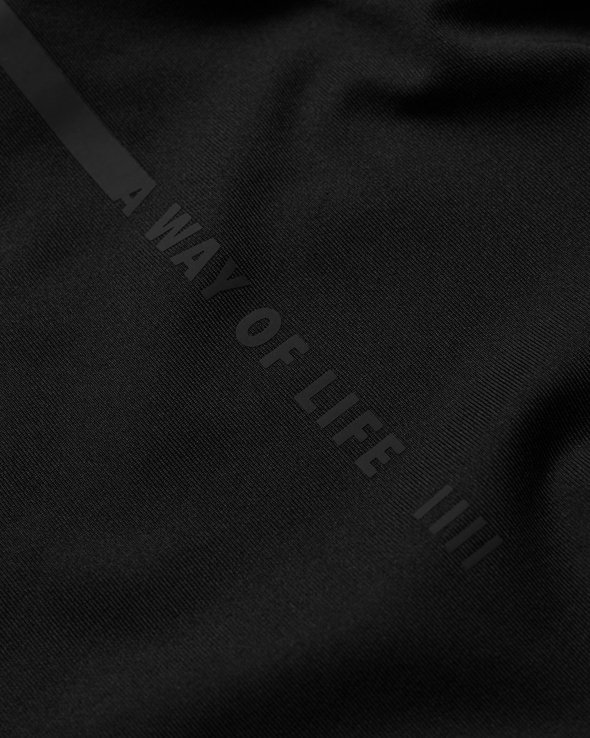 Black fabric with 'A Way of Life' text on a dark background