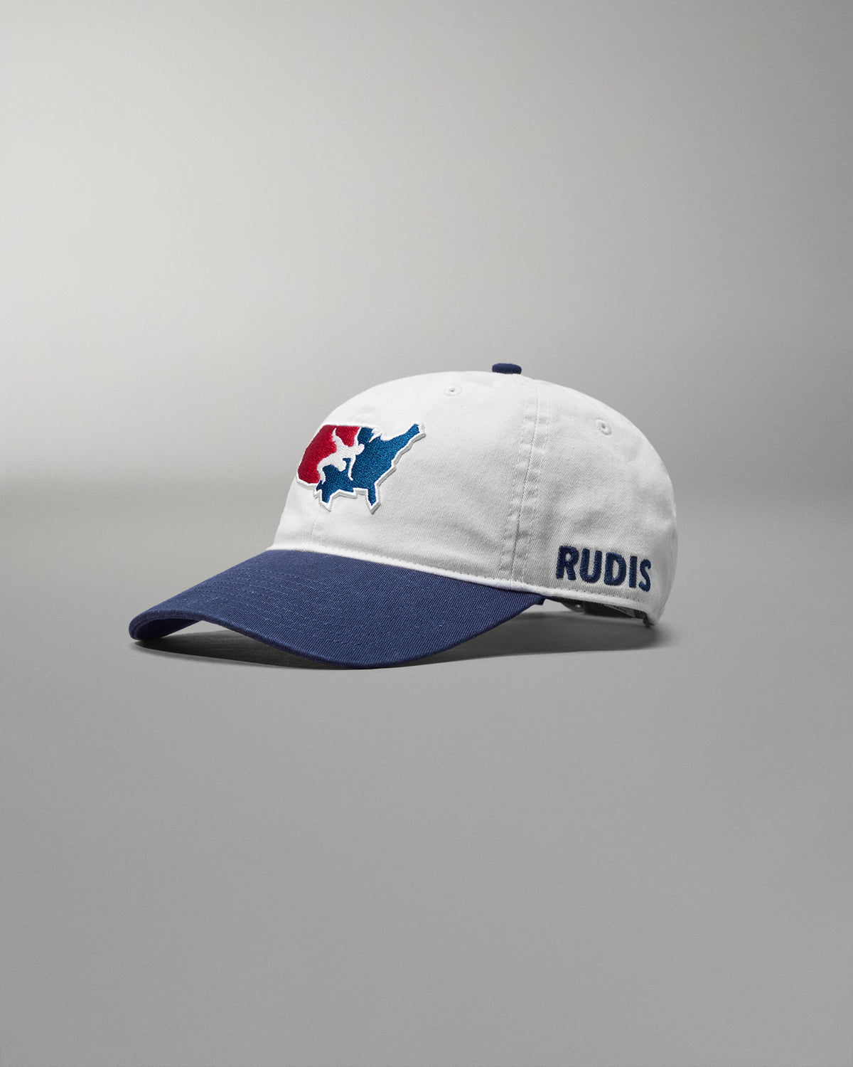 White and blue cap with a USA Wrestling logo and 'RUDIS' text on a gray background