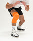 Person wearing an orange knee pad on a white background