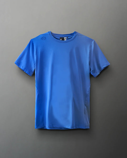 A blue athletic t-shirt hangs against a soft gray background, showcasing its lightweight fabric and brand logo on the shoulder.
