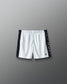 White shorts with black side panels on a gray background