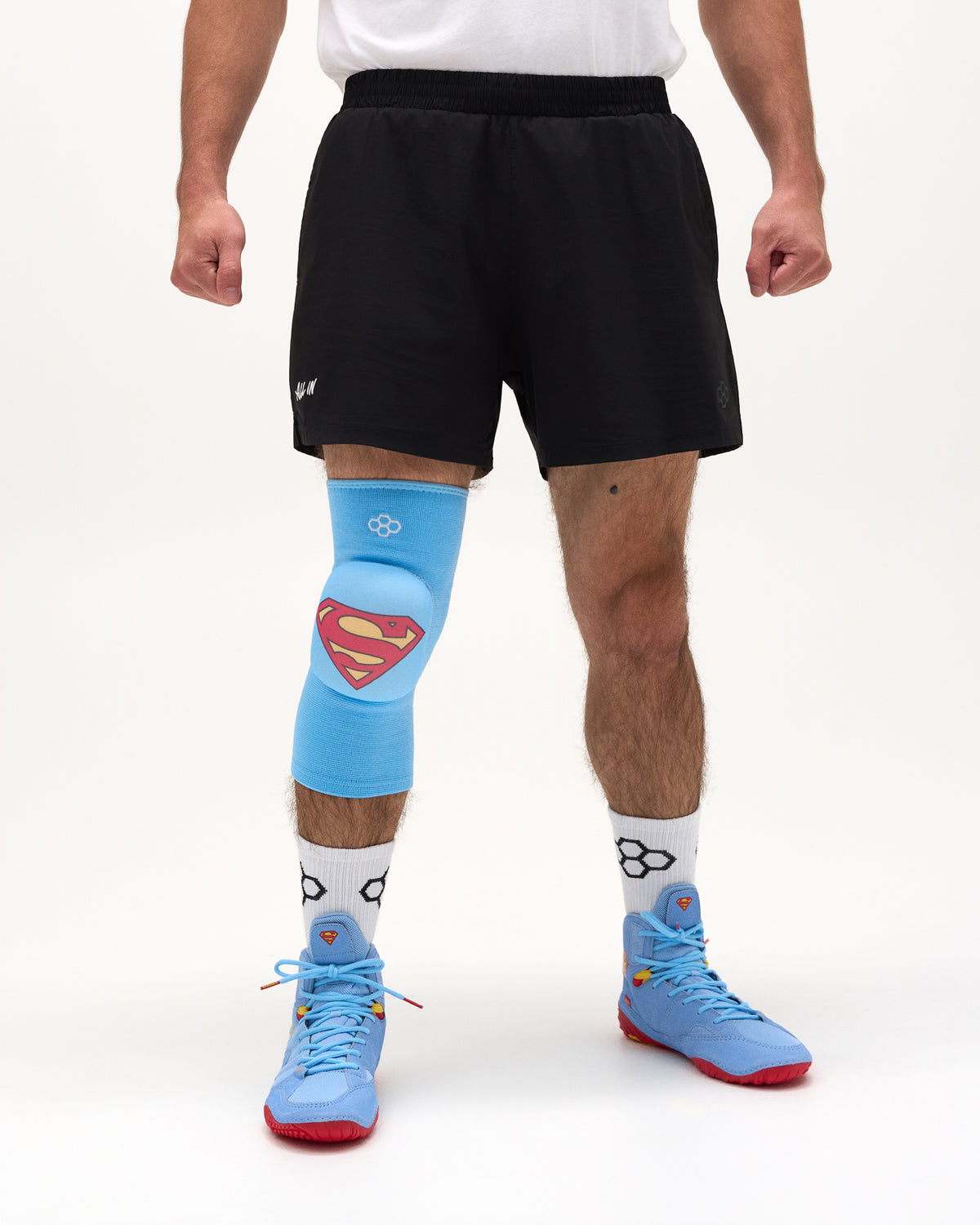 Front view of wrestler wearing the blue RUDIS Superman Cushion Kneepad with padded Superman shield over the knee.