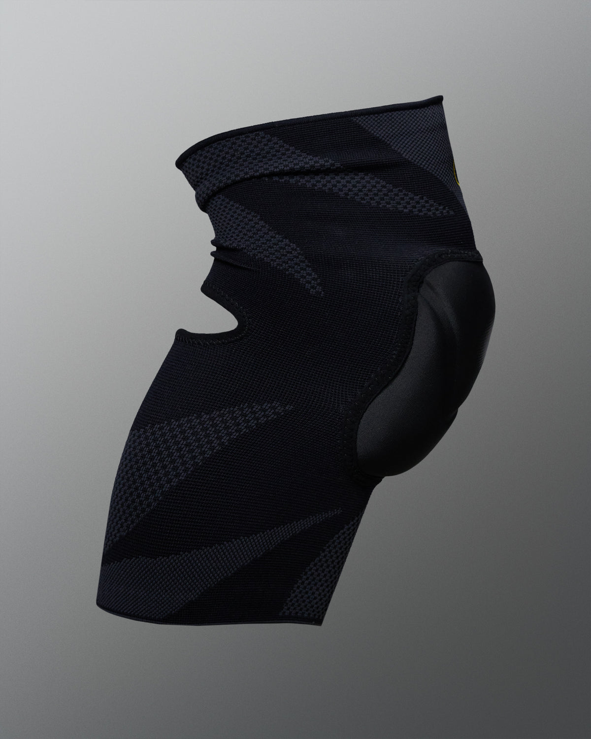 Rear angled view of the RUDIS Batman Elite Cushion wrestling knee pad showing the black compression sleeve and contoured knee padding.