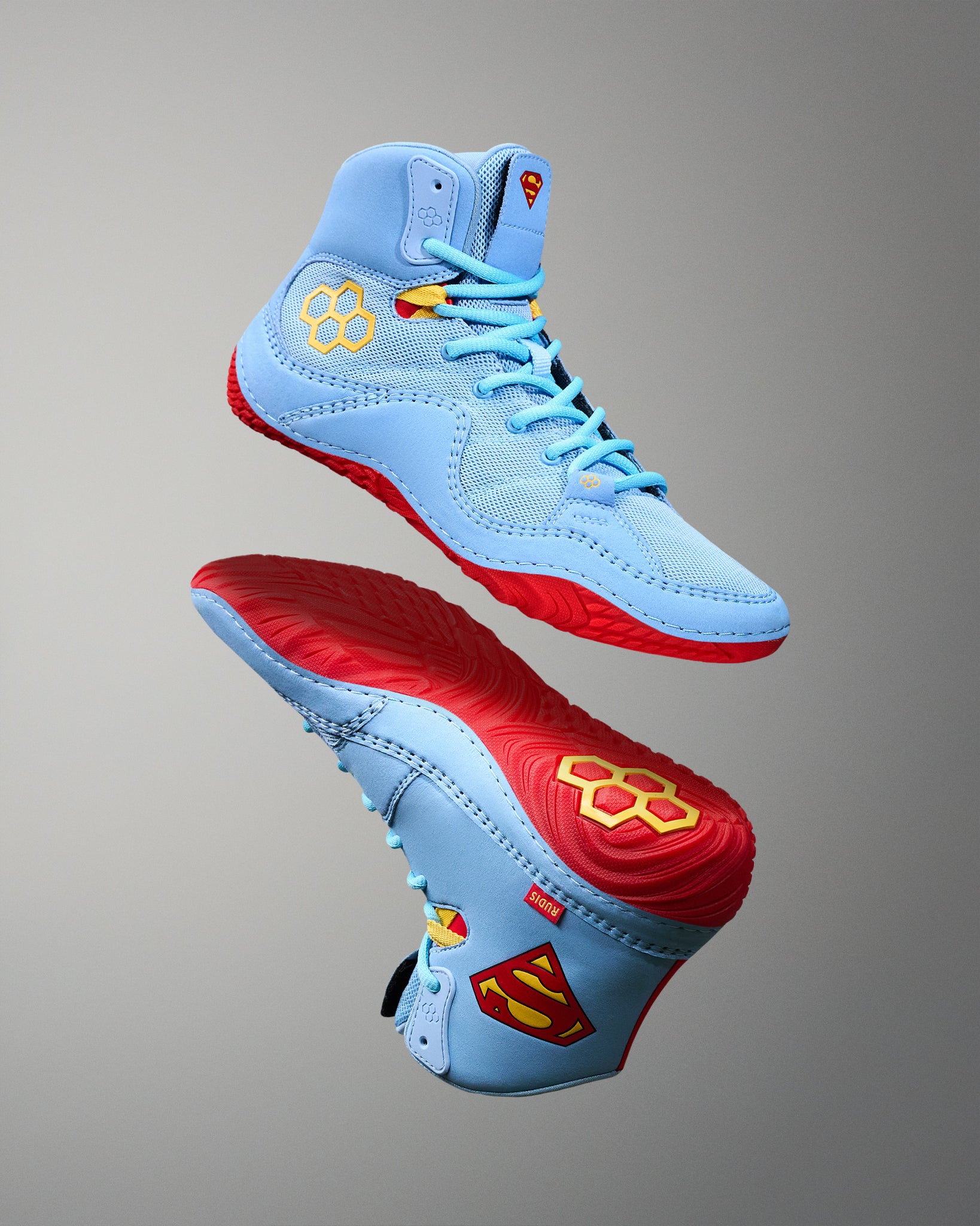 RUDIS JB1 Superman wrestling shoes in light blue with red outsoles, yellow accents and Superman-inspired details.