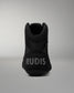 A black high-top wrestling shoe shown from the back, featuring the brand name 'RUDIS' in light gray text on the heel, set against a neutral gray background.