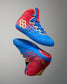 Angled view of RUDIS Wonder Woman Hildebrandt 2.0 women's wrestling shoes, showcasing blue and red uppers, gold RUDIS logos, blue laces and Wonder Woman graphics.