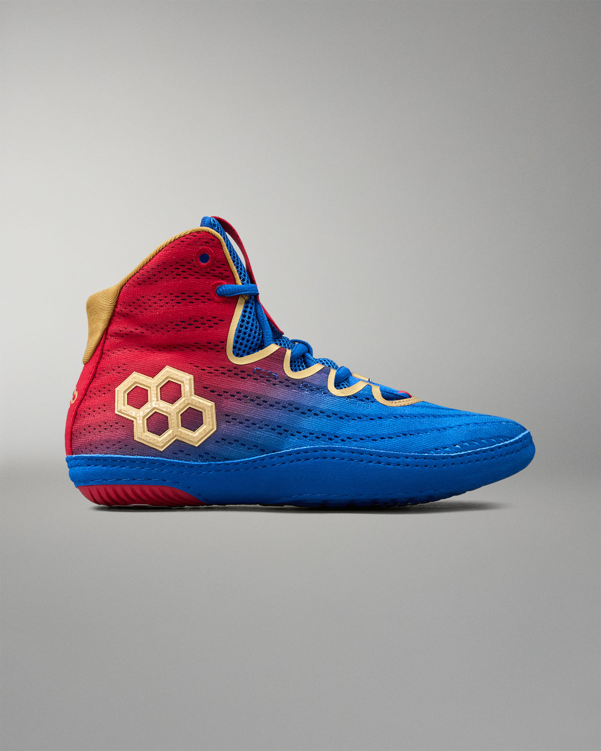 Outer side view of RUDIS Wonder Woman Hildebrandt 2.0 women's wrestling shoe in red and blue with gold accents, textured upper and signature gold RUDIS logo.