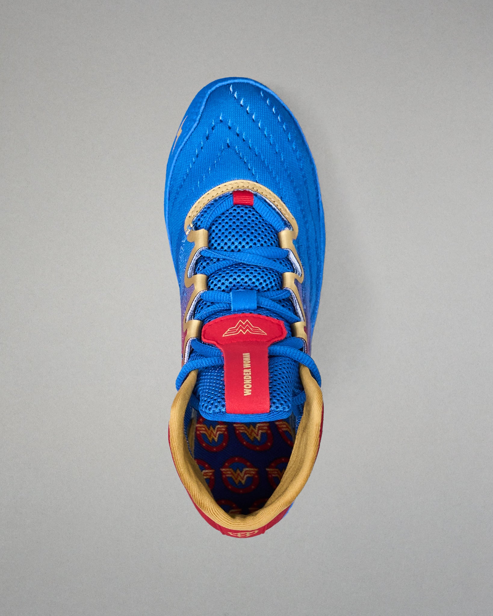 Top view of RUDIS Wonder Woman Hildebrandt 2.0 women's wrestling shoe, featuring blue laces, gold trim, red Wonder Woman tongue branding and printed insole.