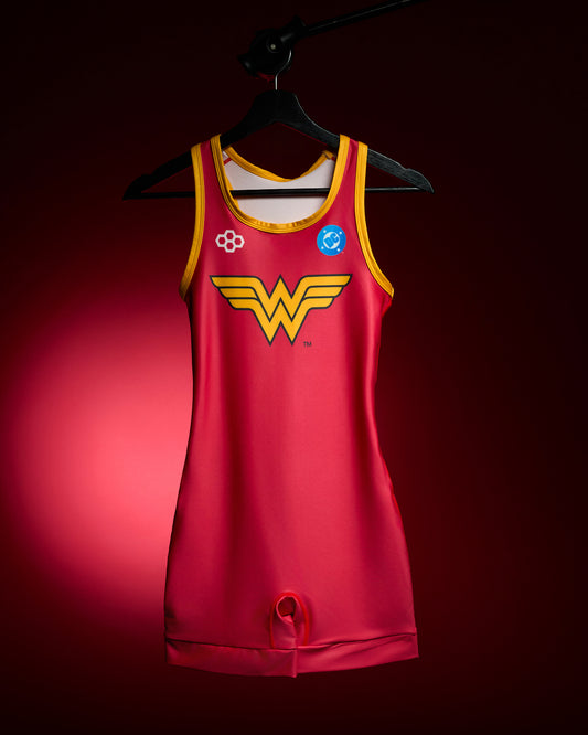 RUDIS Wonder Woman Logo Women's Elite 2.0 Wrestling Singlet in red with yellow trim, iconic Wonder Woman chest emblem and DC Comics branding, displayed on a hanger against a red background.