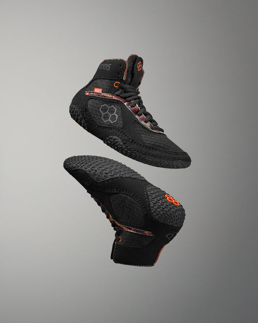 Black high-top sneakers with orange accents on a gray background