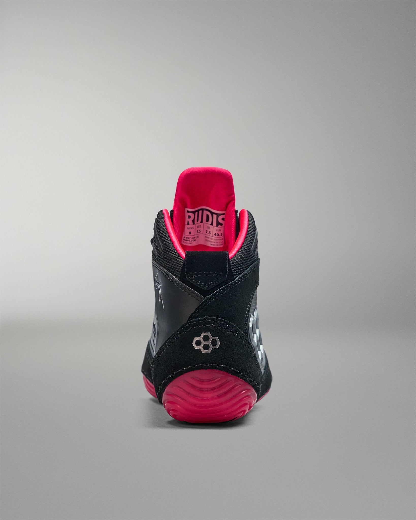 Black and pink wrestling shoe on a gray background