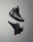 Black wrestling shoes with gray soles on a gray background