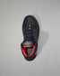 Black wrestling shoe with red interior on a gray background