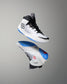 Pair of white wrestling shoes with black and blue accents on a gray background