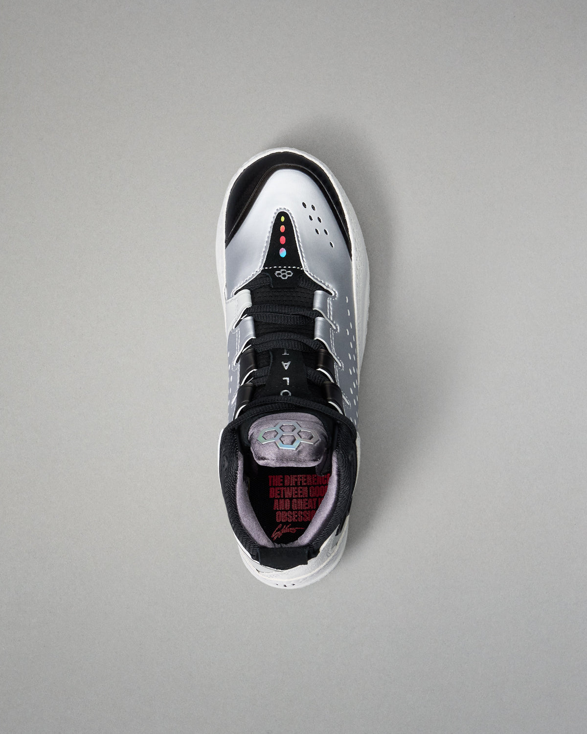 Black and white wrestling shoe with red accents on a gray background