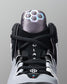 Close-up of a black and gray wrestling shoe with a hexagonal pattern on a gray background