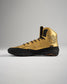 This image presents a striking pair of gold athletic shoes designed for performance featuring a high-top silhouette with black accents and intricate detailing