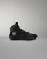 Black high-top wrestling shoe with a logo on a gray background