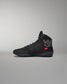 Black high-top wrestling shoe with a logo on a gray background