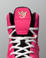 Close-up of a pink and black wrestling shoe with white laces on a gray background